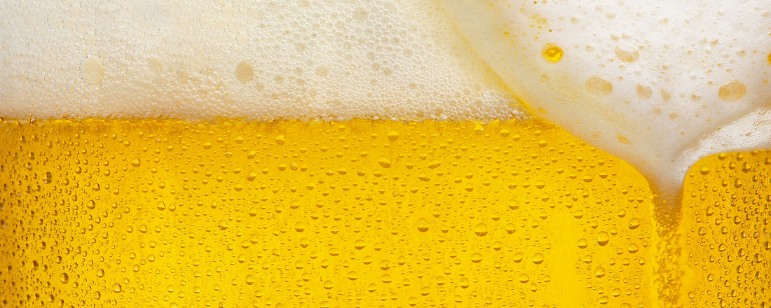 Nahaufnahme Bier, goldgelbe Flüssigkeit mit Kohlensäurebläschen